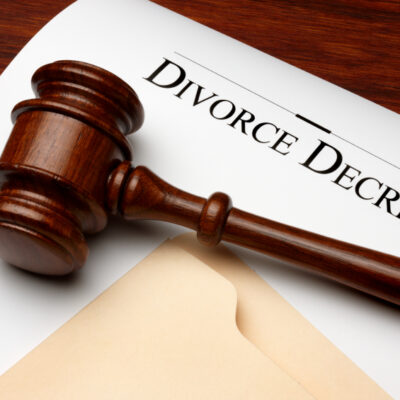 Divorce decree, gavel and folder shot on warm wooden surface